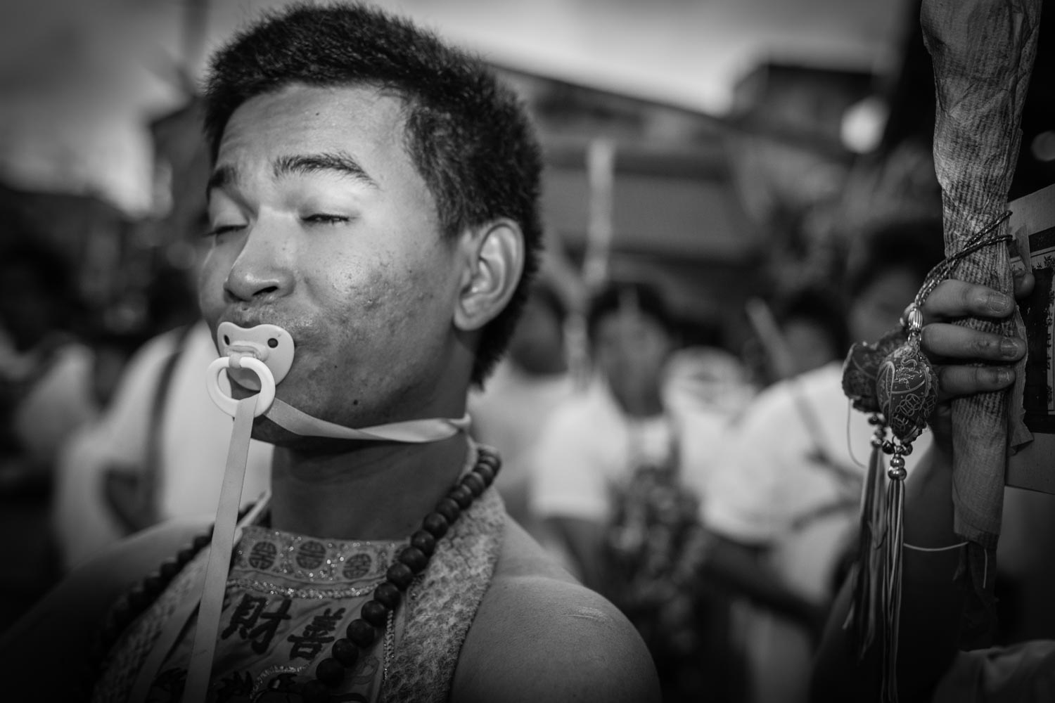 man sucking on a baby dummy during Phuket Vegetarian Festival