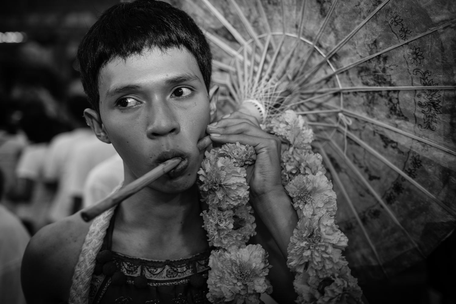 man pierced cheek umbrella phuket vegetarian festival