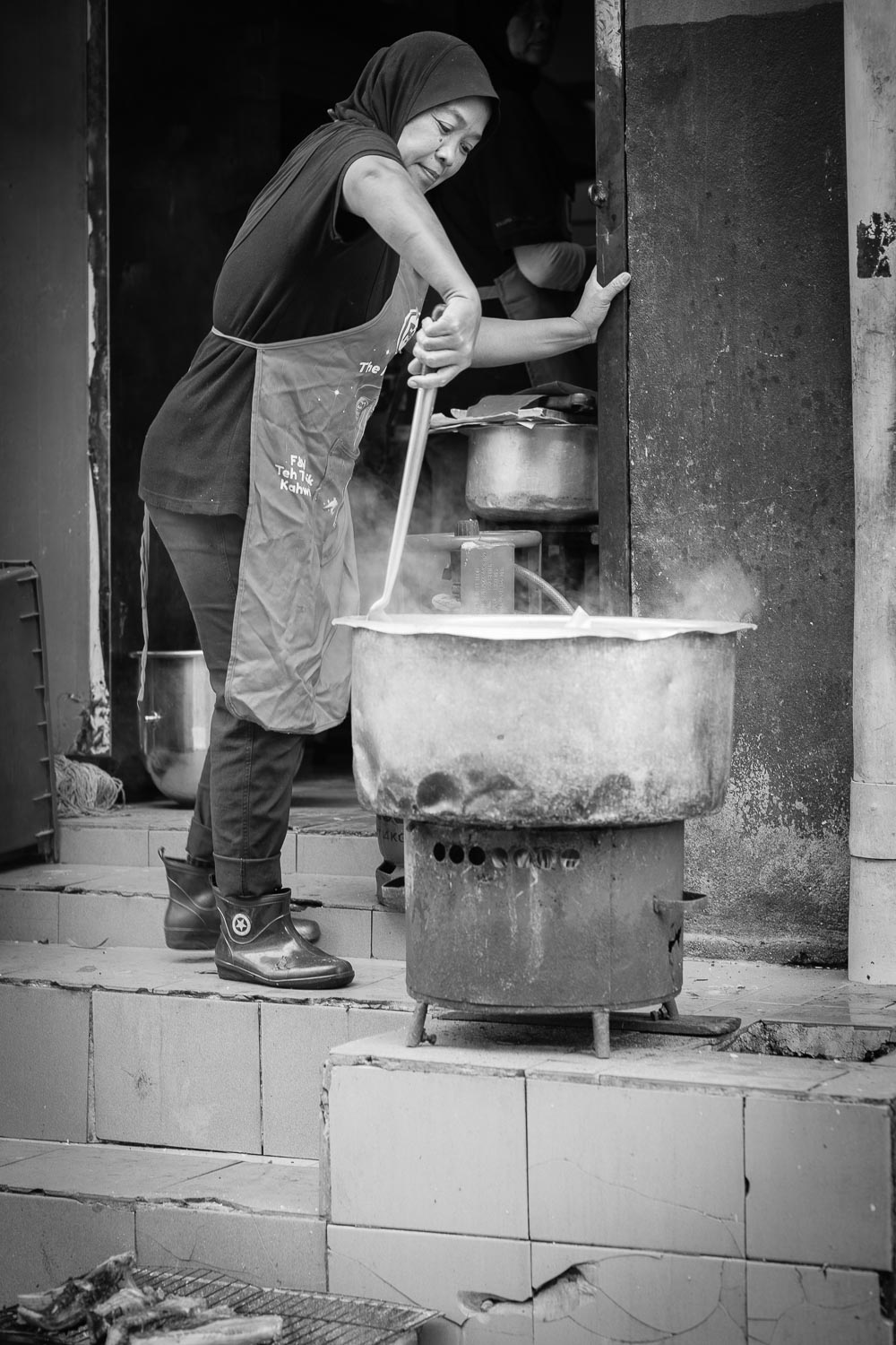 women stirring bags rice large vat